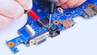 a person is working on a laptop motherboard